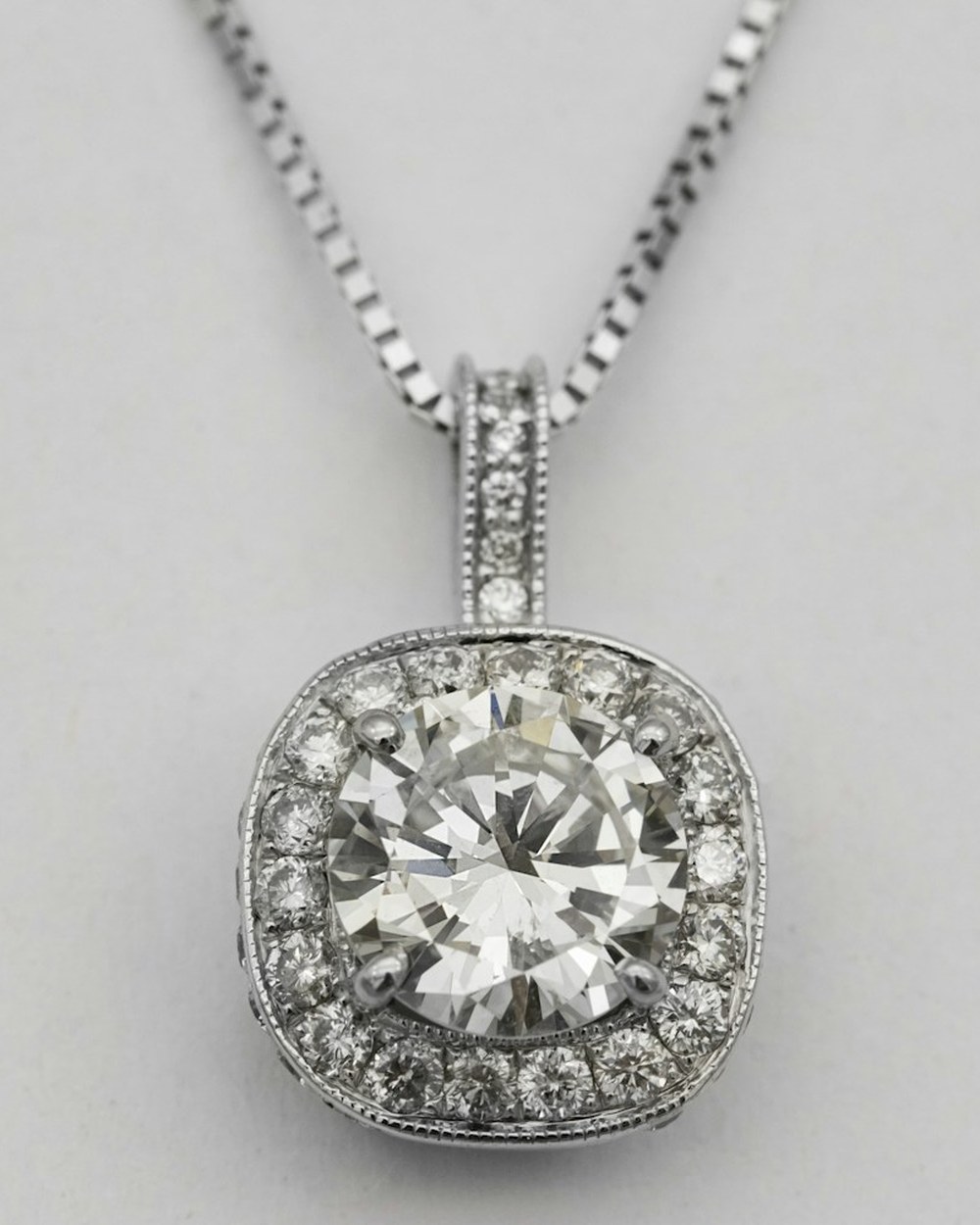 Photorealistic concept visual of a cushion halo solitaire gemstone pendant. Illustrative design reference only, not current shop stock.