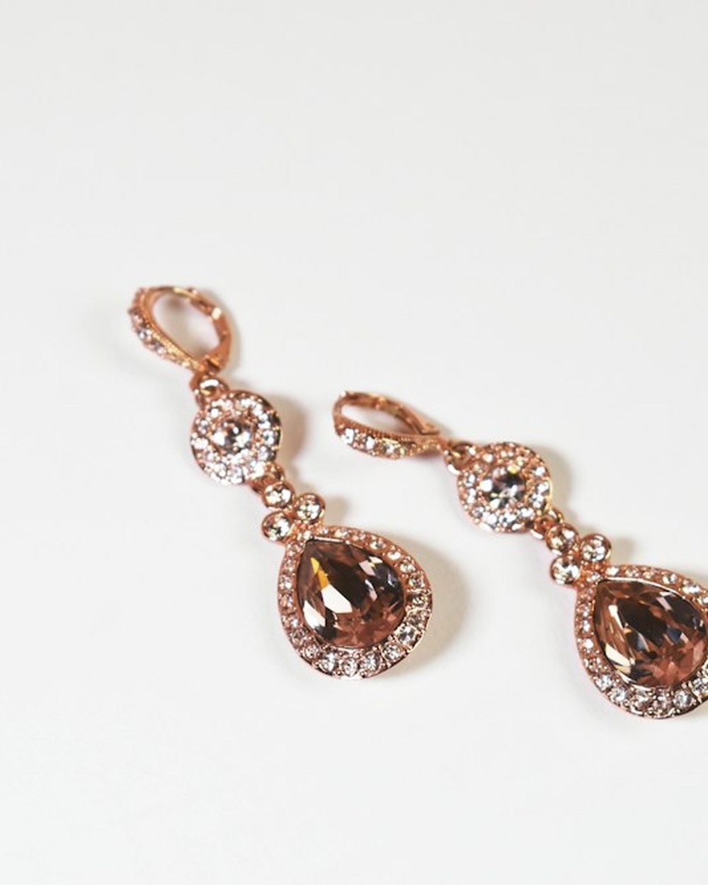 Photorealistic concept visual of gold-toned teardrop crystal drop earrings. Illustrative design reference only, not current shop stock.