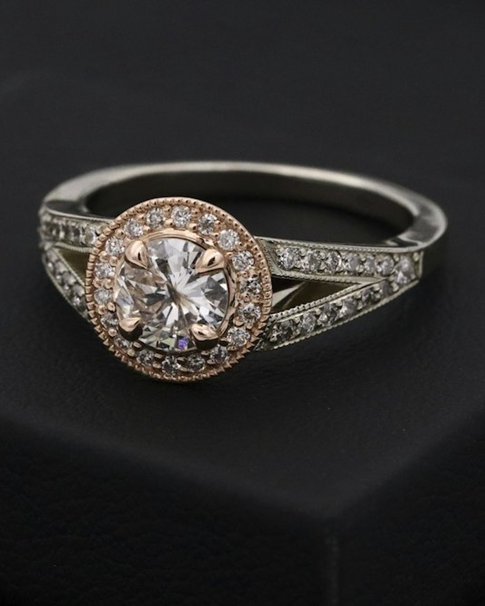 Photorealistic concept visual of an elegant gold-toned ring with raised stone setting on dark velvet. Illustrative design reference only, not current shop stock.
